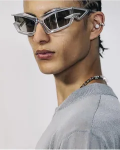 Close-up of futuristic geometric grey sunglasses with gradient lenses on a fashion model