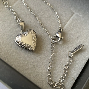 Detailed view of heart-shaped stainless steel locket pendant with vintage floral engraving