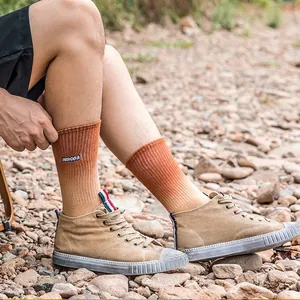 Gradient orange cotton socks with Aurora embroidery and khaki high-top sneakers outdoors