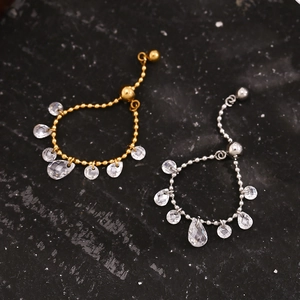 Detail of adjustable 18K gold and silver bead chain rings with drop crystal pendants