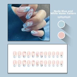 Detailed view of long trapezoid press-on nails with blue-white water ripples and rhinestones