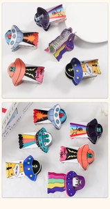 Detail view of alien and UFO themed hair claws with colorful acetate finishes
