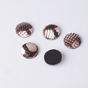 Macro detail of 14mm rose gold fish scale resin cabochons with flat black backing