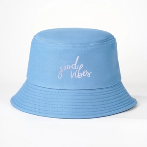 Detail of light blue cotton bucket hat with white good vibes embroidery and stitched brim