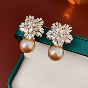 Luxus Goldene Blumenohrringe mit Kristallsteckern und Perlen auf einer grünen Box