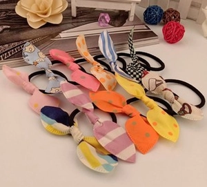 Close-up of rabbit ear hair ties with polka dots and stripes on black elastic bands