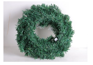 Detailed close-up of a green PVC Christmas wreath with festive house decorations