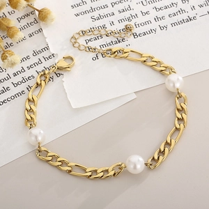 Detail of gold Figaro chain bracelet with three white pearls on vintage script paper