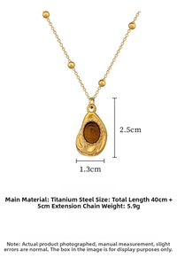 Detail of titanium steel gold necklace with irregular water drop amber stone pendant