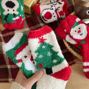 Festive coral fleece Christmas socks featuring reindeer and Santa Claus patterns