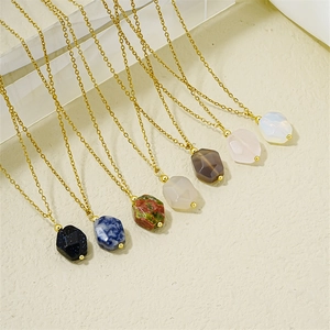 Close-up of seven colorful natural stone pendants on gold chains over a beige background