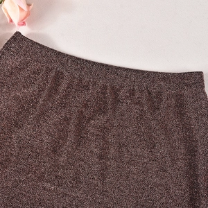 Gros plan sur la texture du tricot pailleté marron foncé avec un éclat métallique