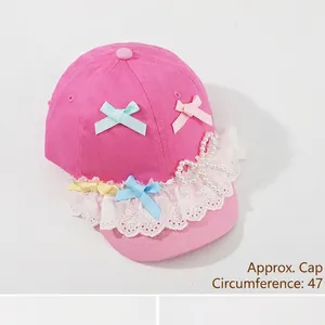 Pink toddler soft-brim baseball cap with white lace embroidery and pearl bow detail
