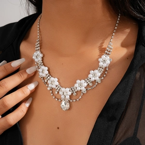 Close-up of a floral rhinestone necklace with pearl waterdrop pendant on a model