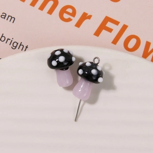Macro shot of glass mushroom bead with white dots on ceramic plate for DIY jewelry making