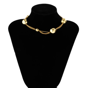 Close-up of golden multi-layer choker necklace with metal beads on black velvet mannequin