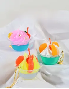 Close-up of miniature cream sundae keychains with colorful fruit toppings and gold chains