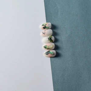 Oval nail art tips featuring hand-painted butterflies with green gradients and aurora glaze