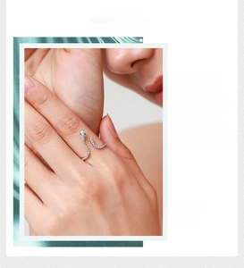Detail of a 925 sterling silver snake ring with pavé zircons and green gemstone eyes