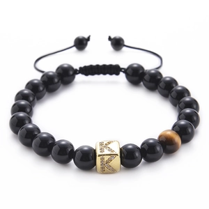 Detail of adjustable black onyx bracelet with tiger eye stone and gold letter K bead