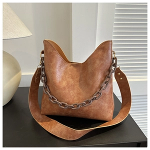 Detail of vintage brown hobo bag with chunky acrylic chain and wide leather strap