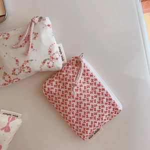 Detail view of cotton floral coin purses with zipper closure and simple wish fabric label