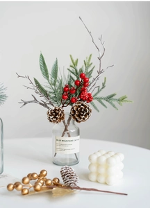 Close-up of Christmas berries, pine cones and needles in a labeled glass vase