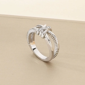 Detailed view of silver knotted ring with sparkling rhinestones and shiny finish