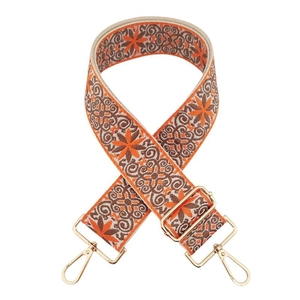 Close-up of wide ethnic embroidered bag strap in orange and brown with gold metal hooks
