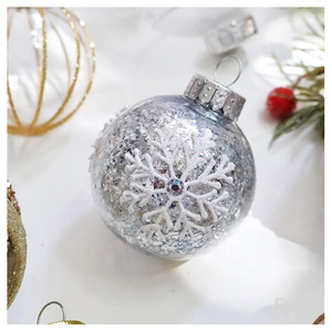 Close-up of a silver sequined Christmas ball with white snowflakes and purple rhinestones