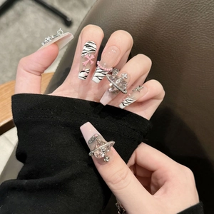 Pink French press-on nails with zebra stripes, resin bows and chrome heart charms