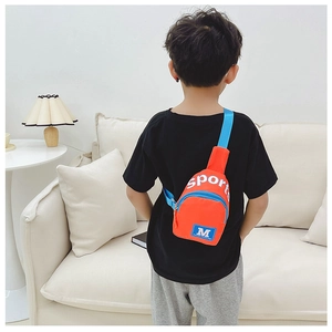 Détail du sac à bandoulière en nylon orange pour enfants avec sangles bleues et motifs