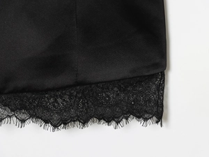 Gros plan d'une robe en satin noir avec une bordure délicate en dentelle de cils au bas