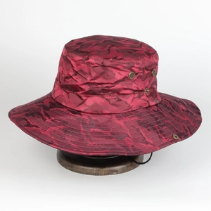 Détail d'un chapeau de soleil camouflage rouge avec large bord et cordon réglable