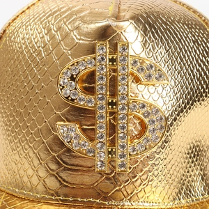 Macro detail of gold crocodile texture and rhinestone dollar symbol on hip hop cap