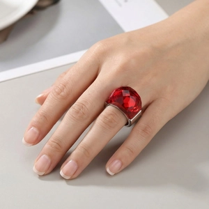 Detail of a large faceted red crystal ring on silver setting worn by a model