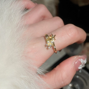 Detailed macro view of a gold-finish star ring with zircon accents on a soft plush cuff