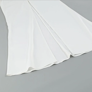 Detailed view of the smooth white fabric and elegant side slit hem on this maxi dress