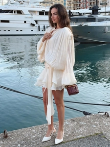 Detail of off-white pleated chiffon mini dress with lantern sleeves and ruffled hem