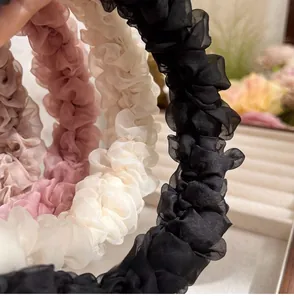 Close-up of pleated mesh headbands in black, beige, pink and mauve showing fabric texture