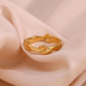 Minimalist gold plated stainless steel ring with irregular wavy texture on silk