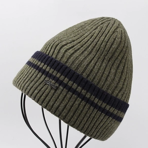 Detail of olive green ribbed knit hat with blue stripes and silver Sport metal badge