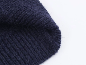 Close-up of navy blue striped knit cardigan showing soft ribbed texture and wool fibers