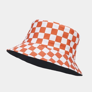 Detail view of double-sided bucket hat with orange and white checkered pattern and black lining