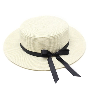 Détail du tissage fin en paille et du ruban noir avec nœud élégant sur le chapeau d'été