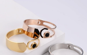 Detailed view of three-tone open metal bangles in gold, rose gold and silver finishes