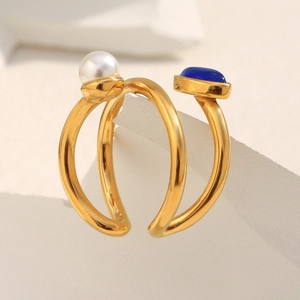 Detail of 18K gold-plated open ring featuring a white pearl and blue gemstone