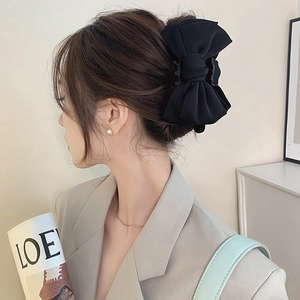 Side view of a girl wearing a large black fabric bow hair claw clip for a princess style