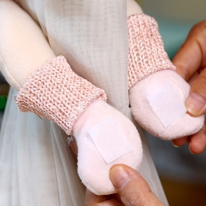 Detail of pink plush doll curtain tieback showing knitted texture and velcro closure