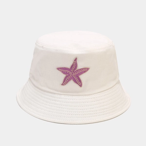 Close-up of purple starfish embroidery on a white cotton bucket hat with twill texture